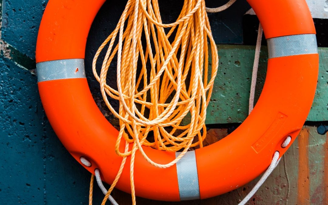 An orange lifeline hanged on a boat figuratevelly expressing the helping hand you need to lend to yourself in order to silence your inner critic.